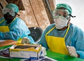 Health workers wearing protective clothing against Ebola virus